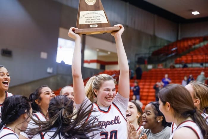 Julianna LaMendola hoists up the University Interscholastic League regional champions trophy for 6A high school girls' basketball.